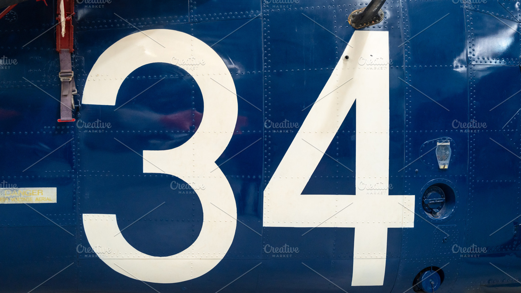 Blue aircraft fuselage with white number 34 and metal details, a Background Photo by GoodGoods