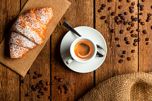Italian breakfast with espresso coffee and croissant on wooden table, a Food & Drink Photo by Antonio Gravante Market