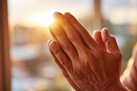 Hands express gratitude and prayer during golden hour with warm sunlight illumi, a Photo by AlyaAnd