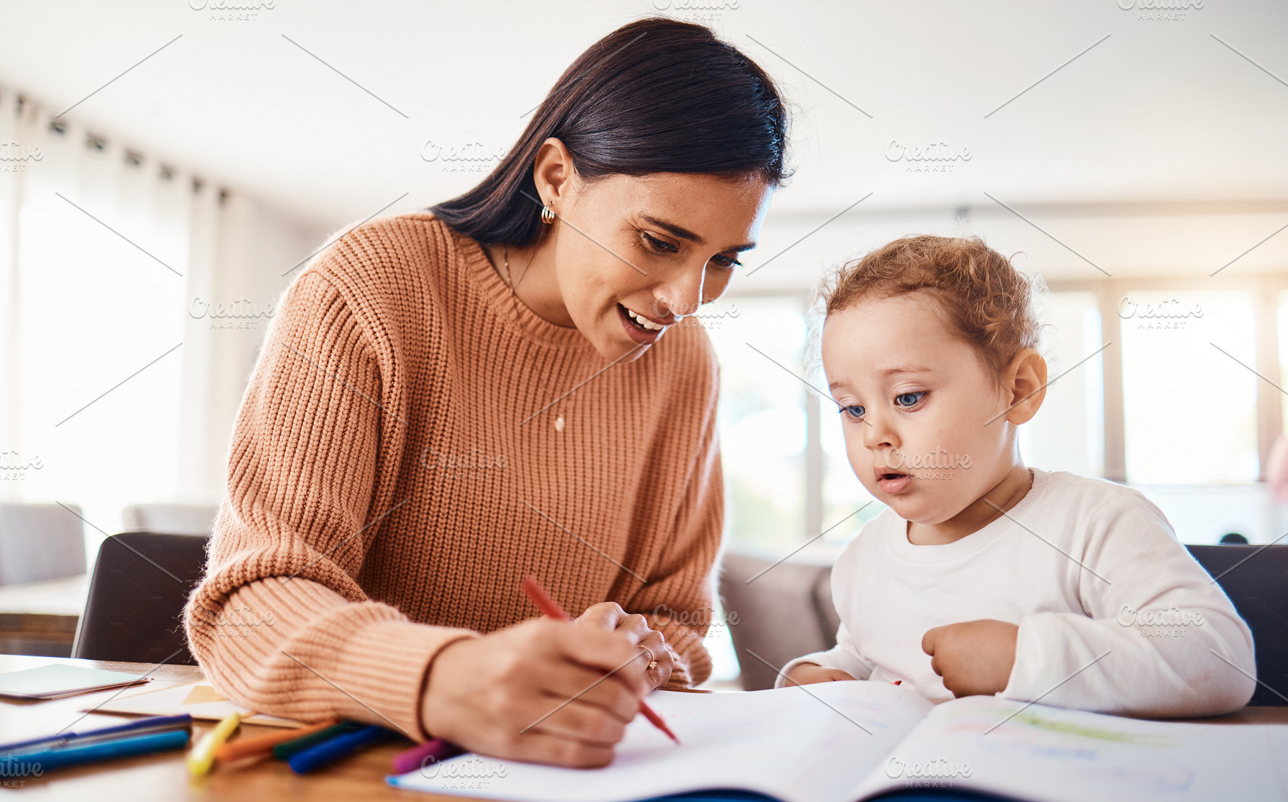 Learning, education and mother with kid drawing in book in home for studying, homework or homeschool. Early development, growth and creative boy with happy mama teaching him art, bonding and care., a Photo by Peopleimages.com