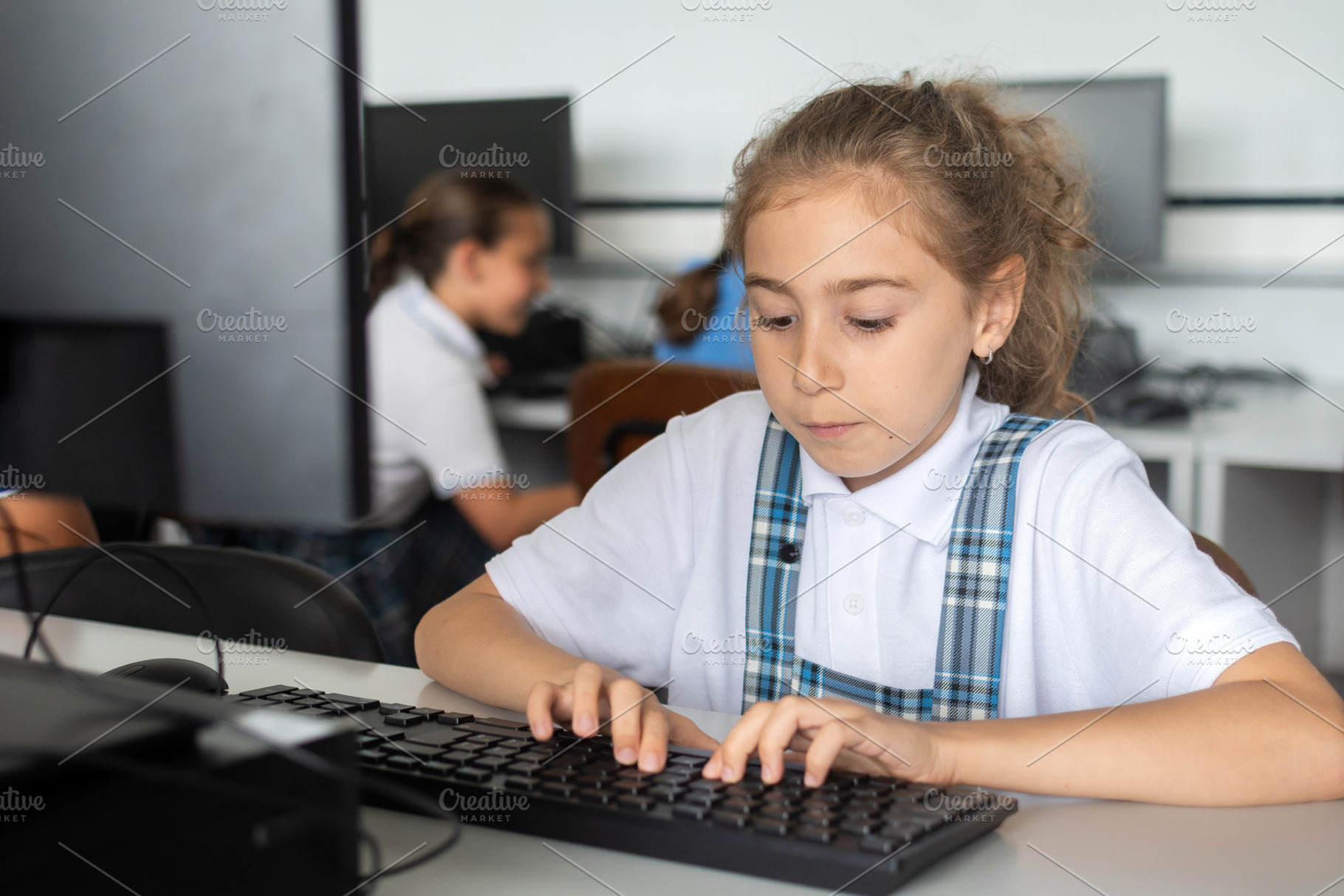 Schoolgirl Typing on Computer During Technology Class, a School & Education Photo by etorres69