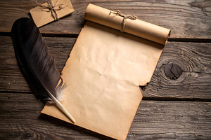 Rolled parchment with feather quill and tied letter nearby, a Holiday Photo by GoodGoods