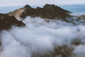 Aerial mountain peak view above clou