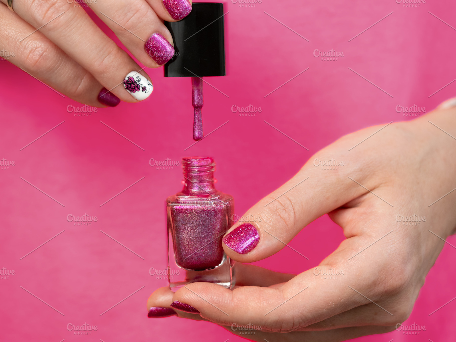 Woman holding pink nail polish brush, a Beauty & Fashion Photo by Fascinadora
