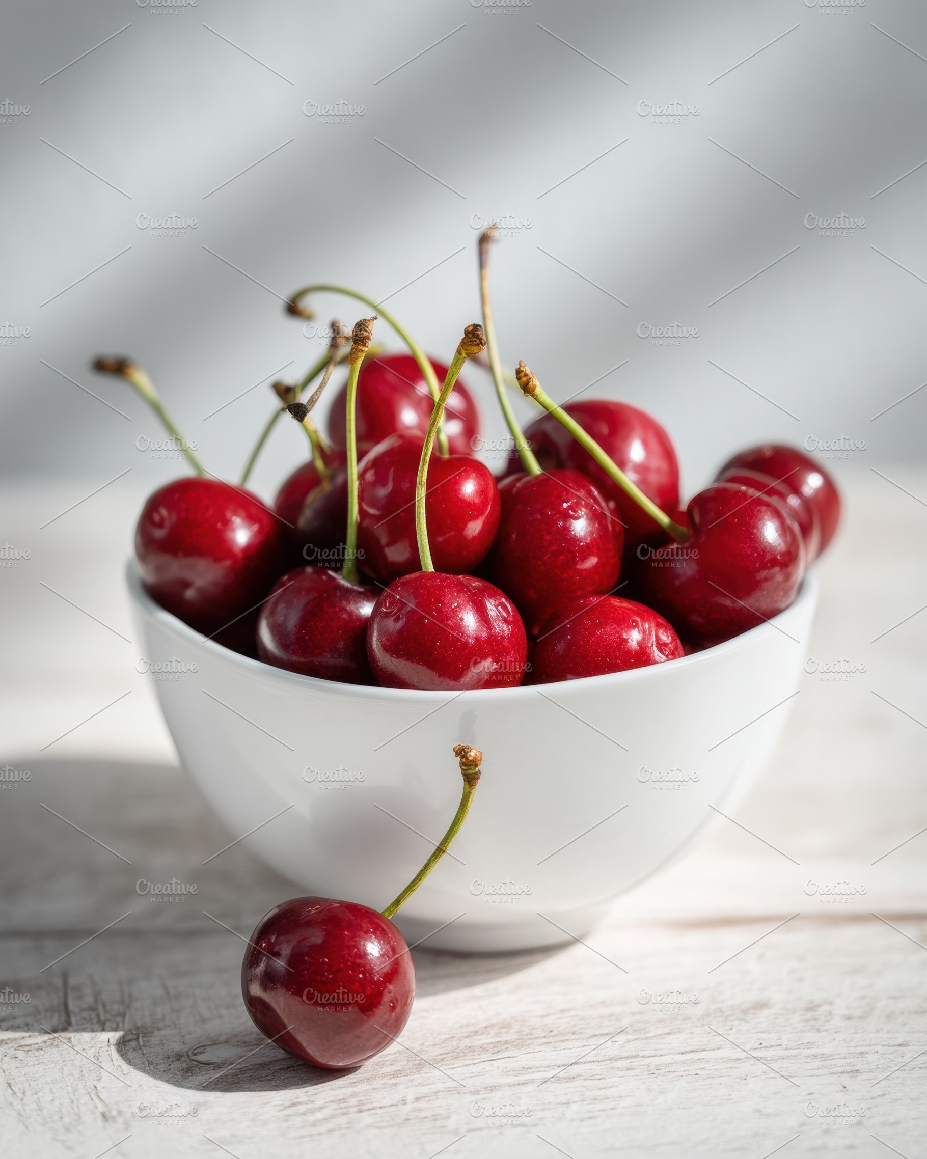 White bowl with cherries on table, a Food & Drink Photo by Virgo Studio