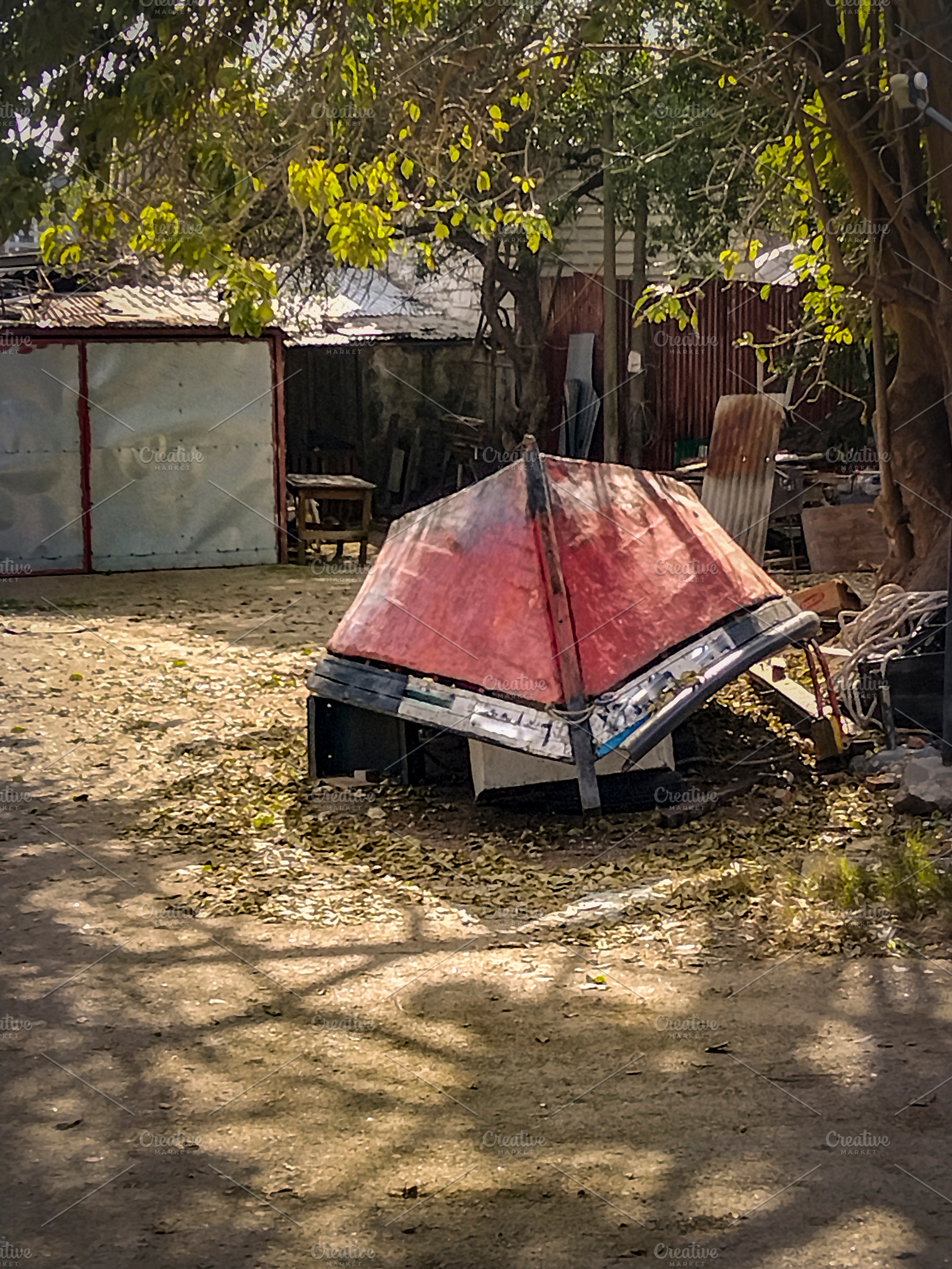 Improvised shelter with boat roof in rural yard, a Food & Drink Photo by DanFLCreativo