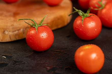 wet small red tomatoes during cooking, red round cherry