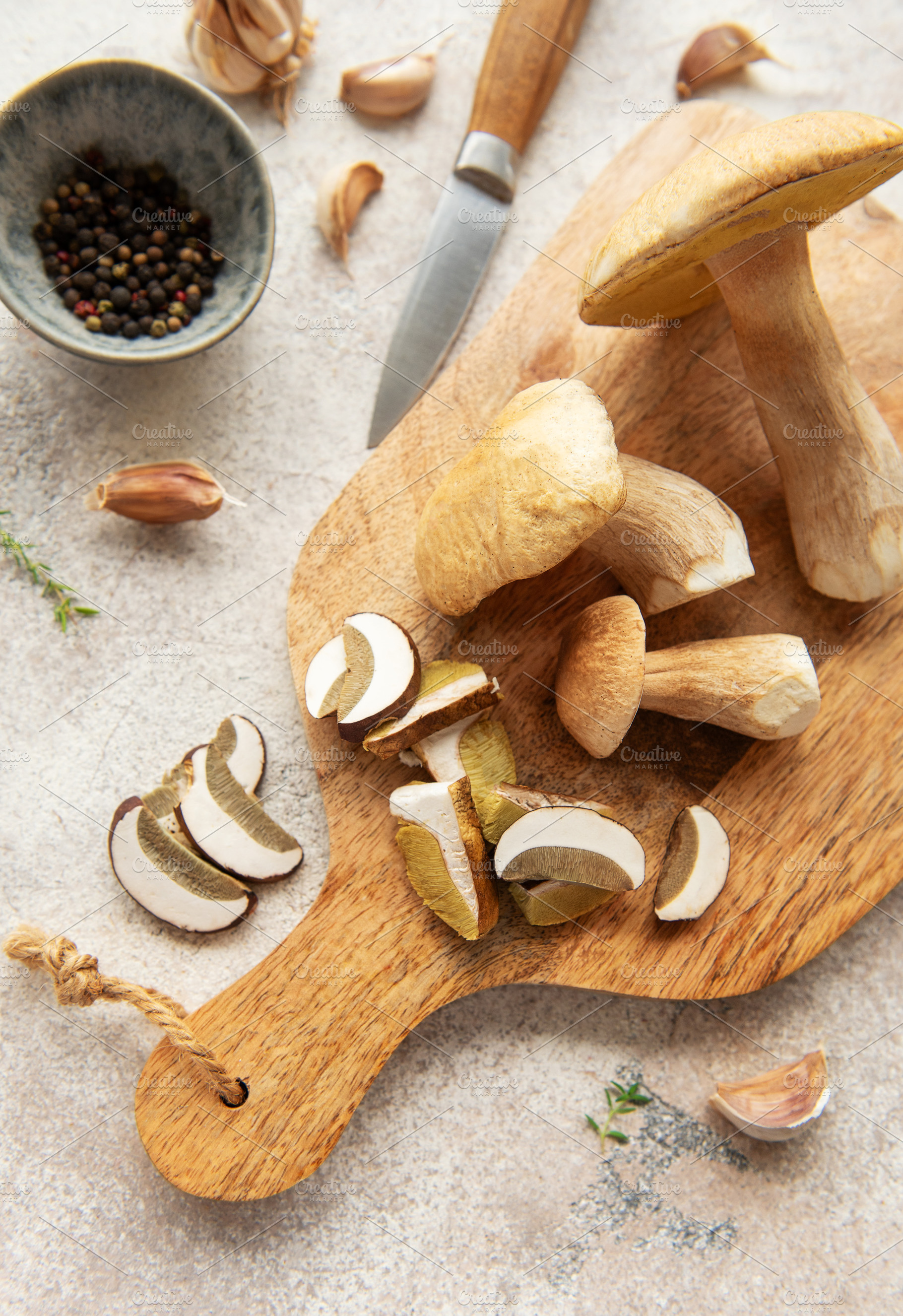 Chef preparing fresh mushrooms with garlic and pepper on cutting, a Food & Drink Photo by Olena Rudo
