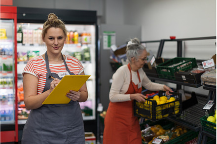 Young shop assistant in supermarket, a Person Photo by HalfPoint