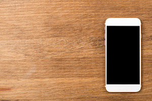 Smartphone on wooden table. Copy space.