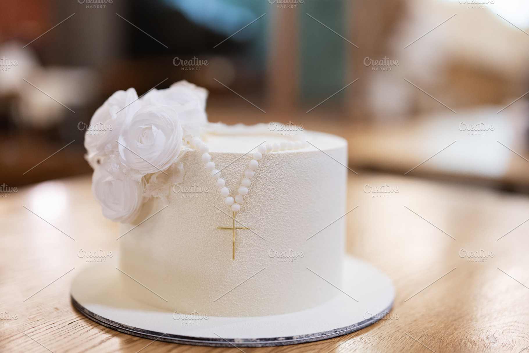Elegant white celebration cake with rosary beads and floral decoration, a Photo by AS photostudio