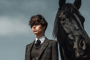 Young man stands with black horse, a Photo by Beautiful things