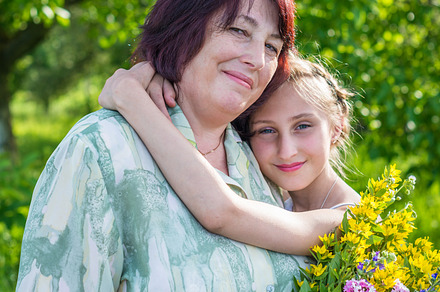 granddaughter hugs her grandmother, a Person Photo by okskukuruza