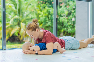Mother and baby lying on a soft play, an Architecture Photo by Elizaveta Galitskaya