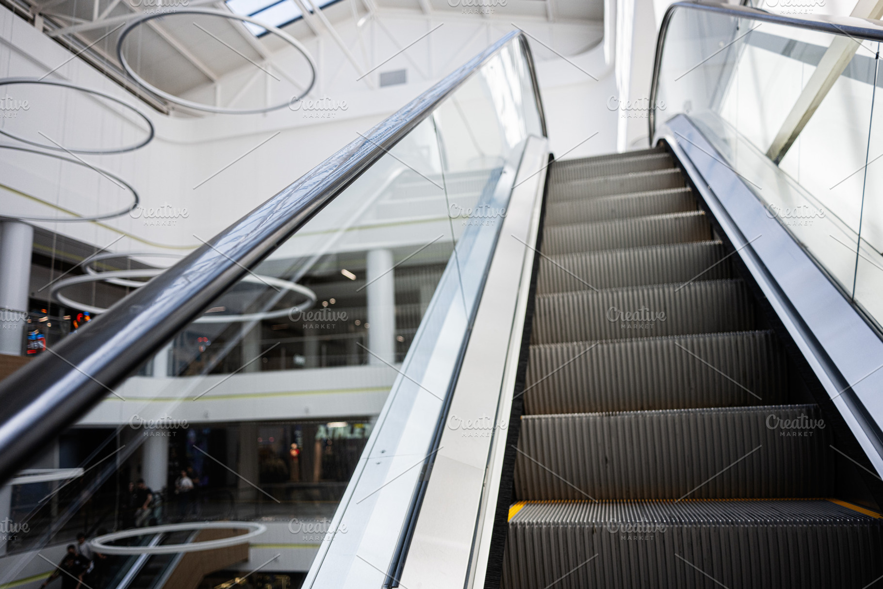 Modern escalator in a bright shopping mall with sleek interior design, a Photo by AS photostudio