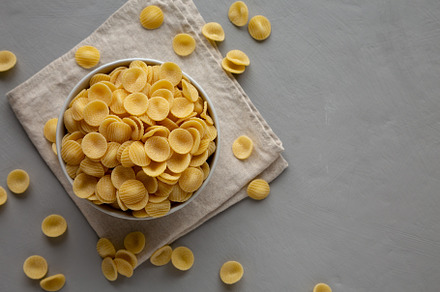 Dry, Uncooked Orecchiette Pasta in a Bowl, top view. Flat lay, o, a Food & Drink Photo by LiudmylaChuhunova
