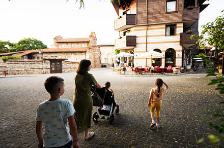 Mother with kids walking in the streets of the old town Nessebar, a Person Photo by AS photostudio