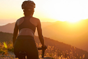 Young cyclist riding on a mountain trail at sunrise, a Sports & Recreation Photo by DanFLCreativo