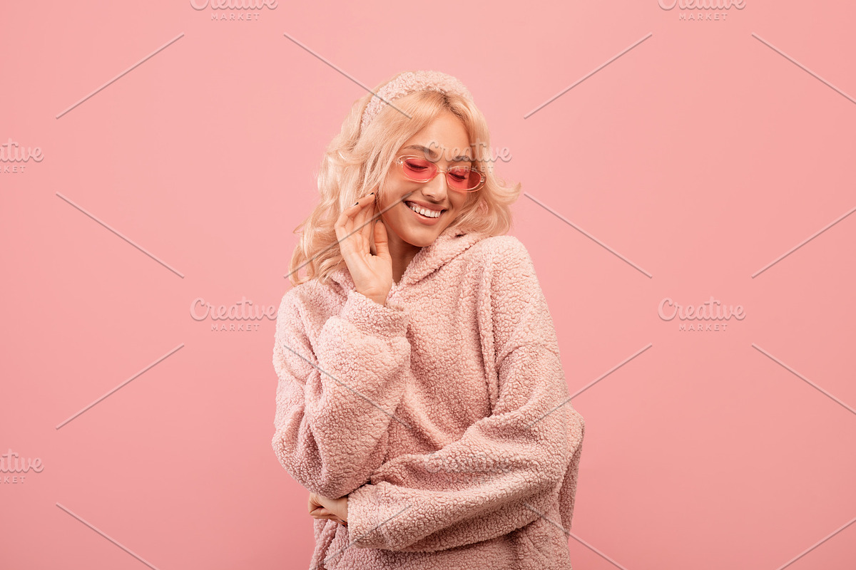 Pretty stylish lady looking down and smiling, wearing colorful sunglasses and h, a Photo by Prostock-Studio (Photo 1 of 2)