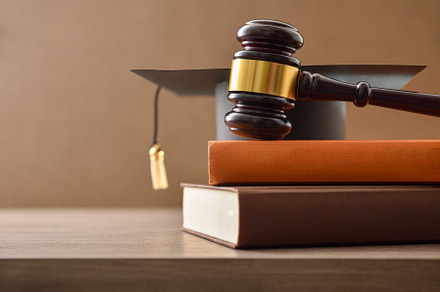 Educational trial with gavel on stack of books on table