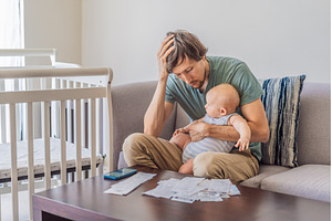 Father sitting on sofa holding baby, a Person Photo by Elizaveta Galitskaya
