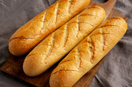 Homemade French Baguette with Garlic Filling on a wooden board,, a Food & Drink Photo by LiudmylaChuhunova