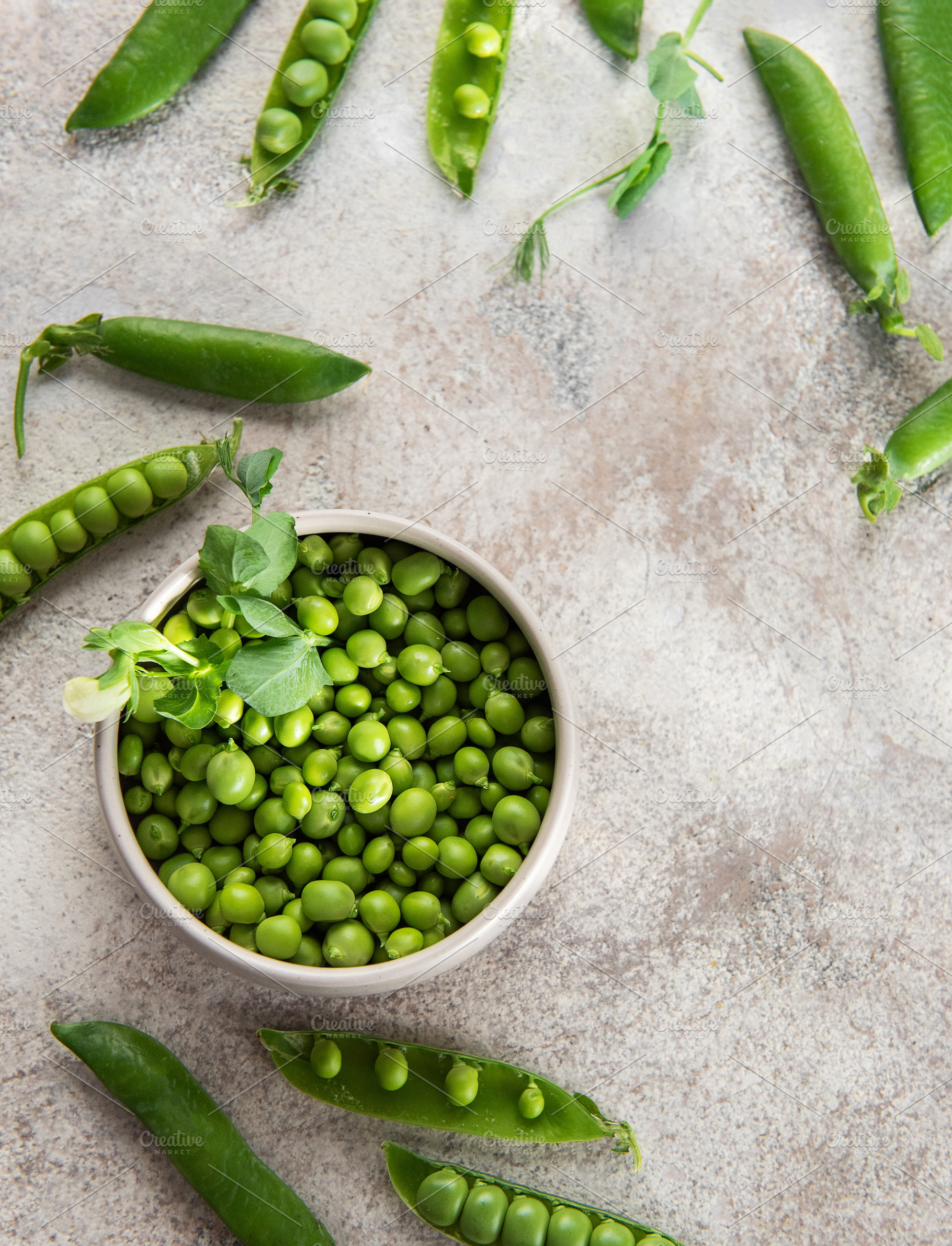 Fresh green peas in bowl and pods on rustic surface, a Food & Drink Photo by Olena Rudo