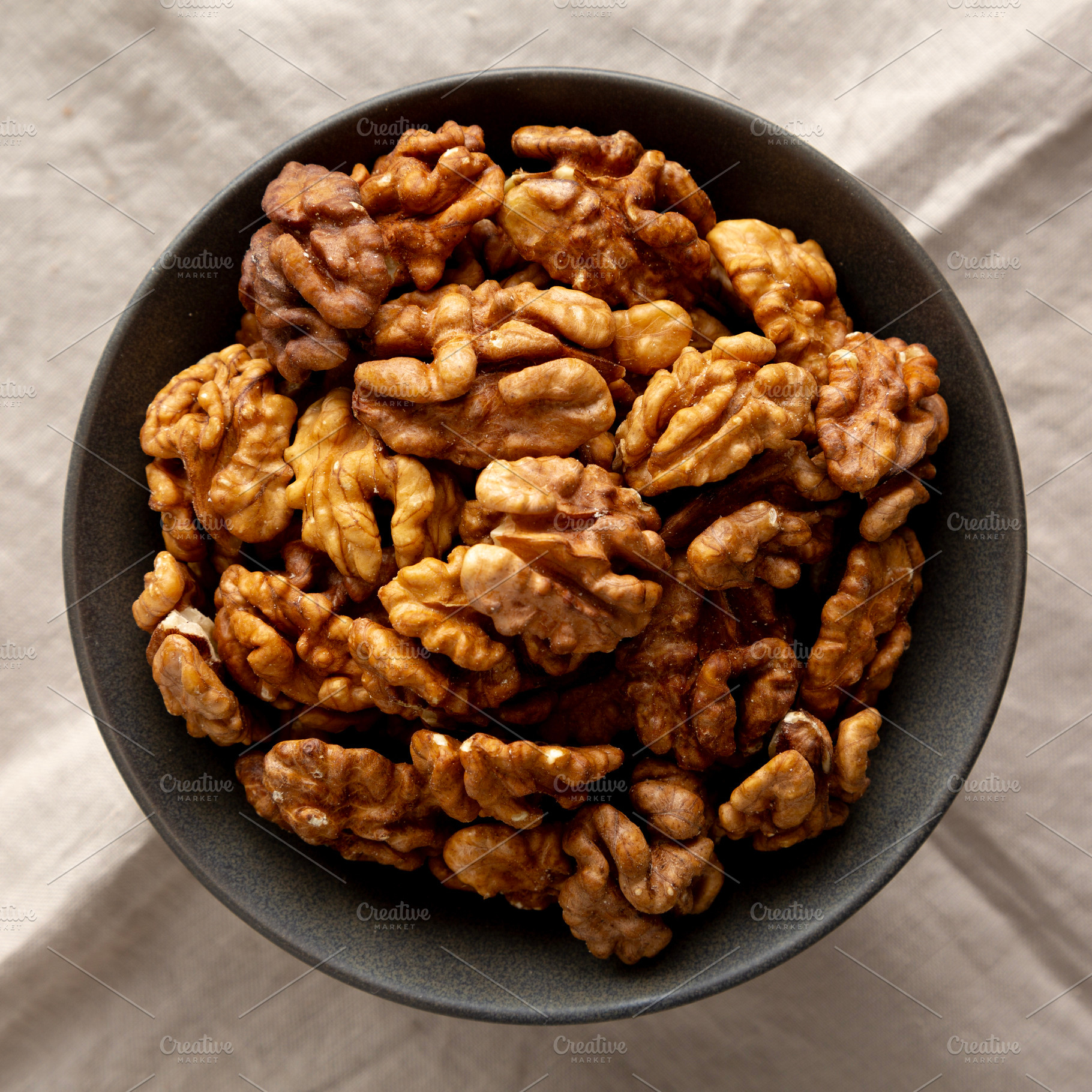 Raw Walnut Halfs in a Bowl, top view. Flat lay, overhead., a Food & Drink Photo by LiudmylaChuhunova