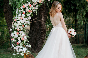A bride in a coral dress with a bouquet against the backdrop of, a Person Photo by Weddings, People, Travel