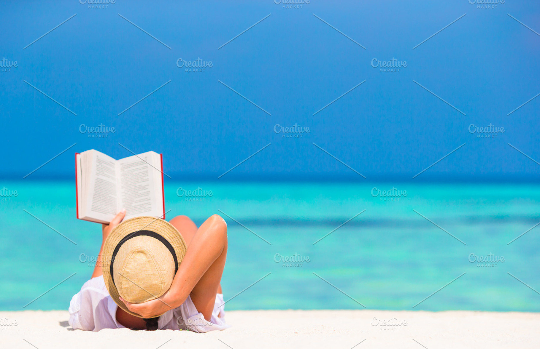 Young woman reading book during tropical white beach containing beach, read, a Person Photo by travnikovstudio
