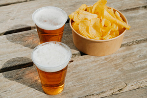 cups of beer and potato chips on a weathered dock, a Photo by Nito