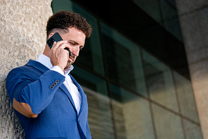Businessman talking on smartphone outside office, a Business Photo by etorres69