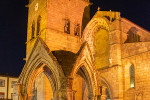 Historic stone chapel with outdoor café at night, guimaraes, po, a Person Photo by DanFLCreativo