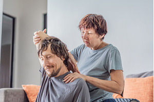 Older woman giving her adult son a, a Person Photo by Elizaveta Galitskaya