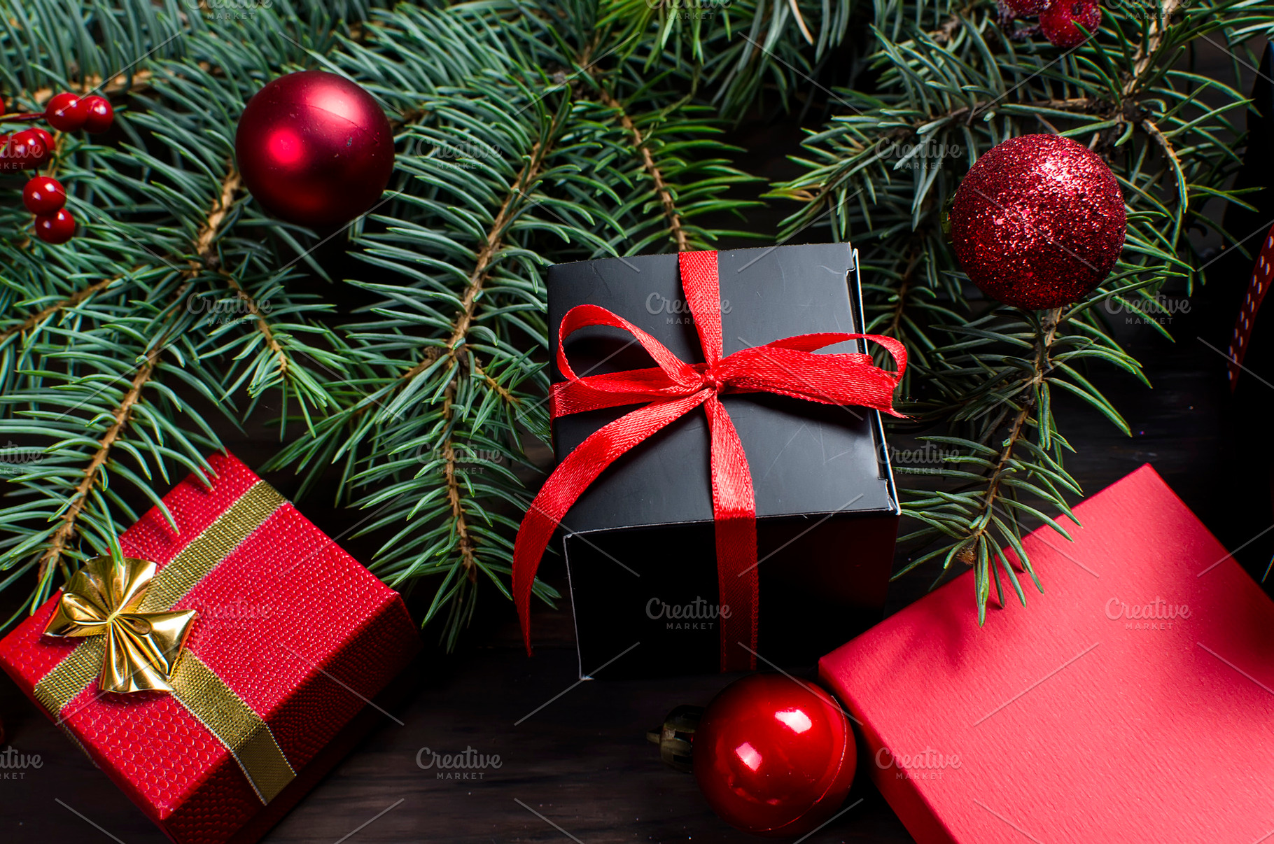 Black and red christmas gift box with red ribbon and fir bran, a Holiday Photo by vimart