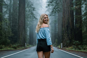 Blonde Woman Smiling on Foggy Road, a Person Photo by Virgo Studio