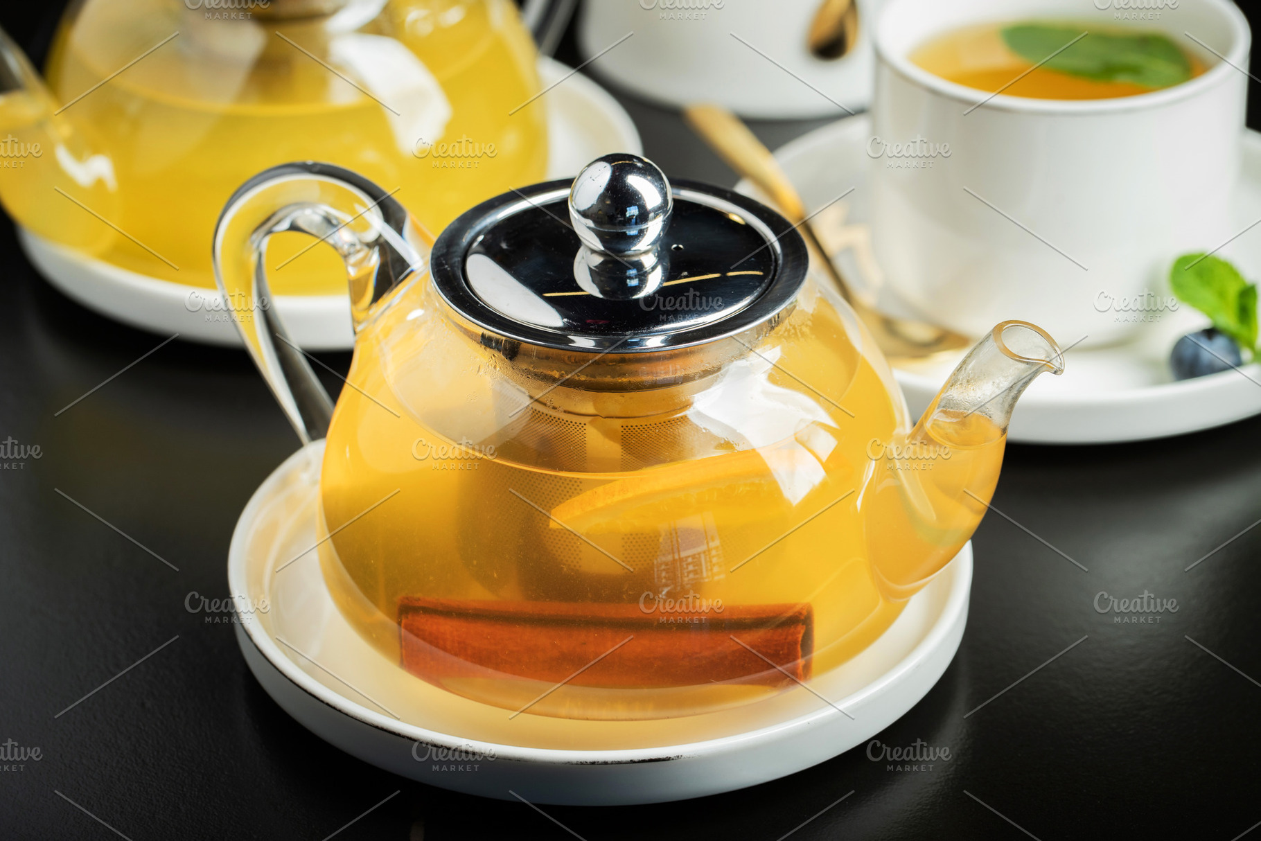 Fruit tea with mango and mint in a glass teapot on the table, a Food & Drink Photo by Budarinphoto