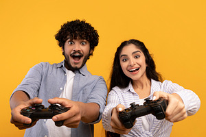 People lifestyle concept. Happy indian couple playing online videogames, using, a Person Photo by Prostock-Studio