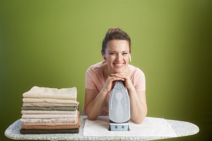 Smiling with the iron: A cheerful domestic scene, a Person Photo by Alliance Images
