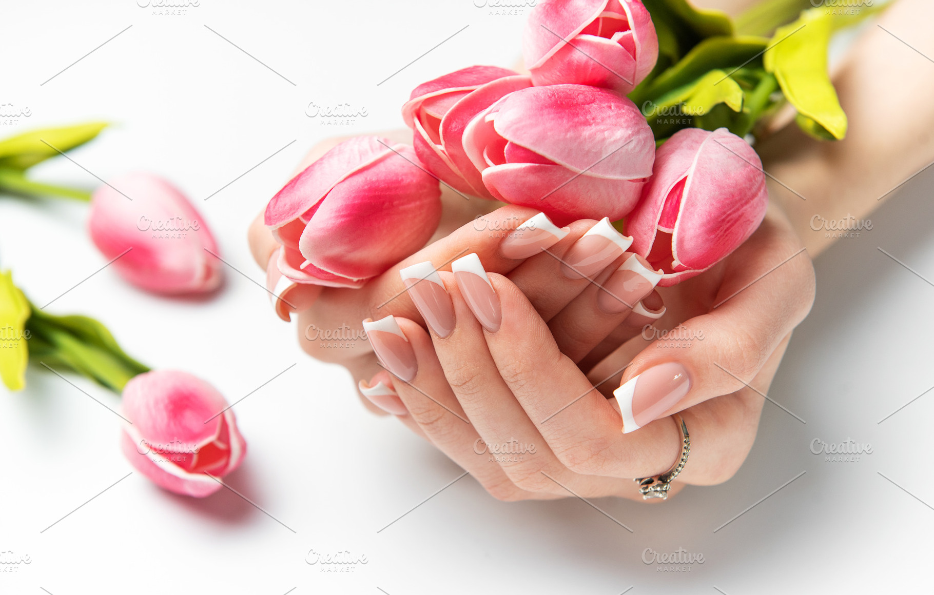 Woman holding pink tulips showing french manicure on white backg, a Beauty & Fashion Photo by Olena Rudo