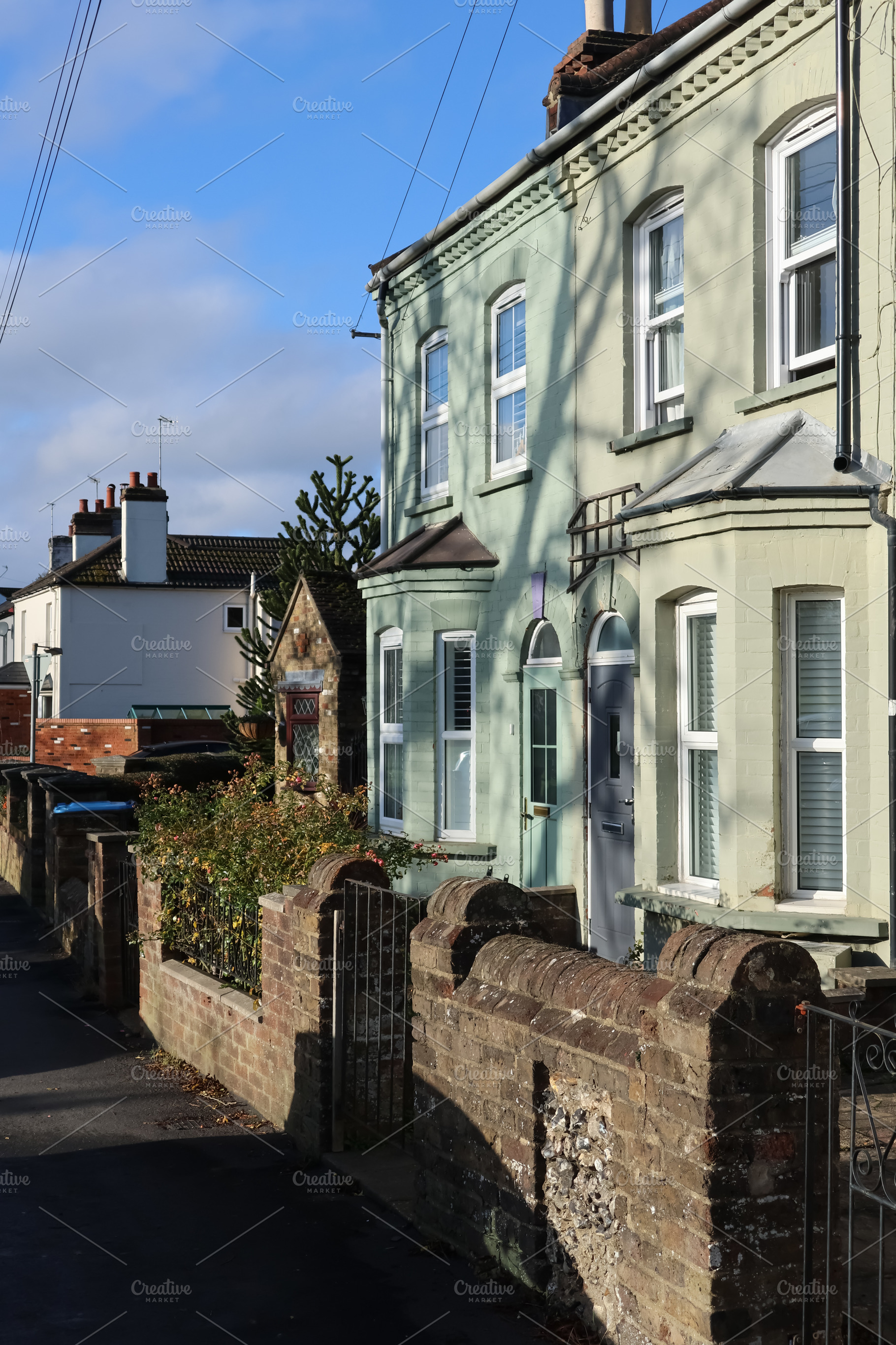 Traditional English terrace houses lining a sunny residential st, a Photo by Studio ANNA