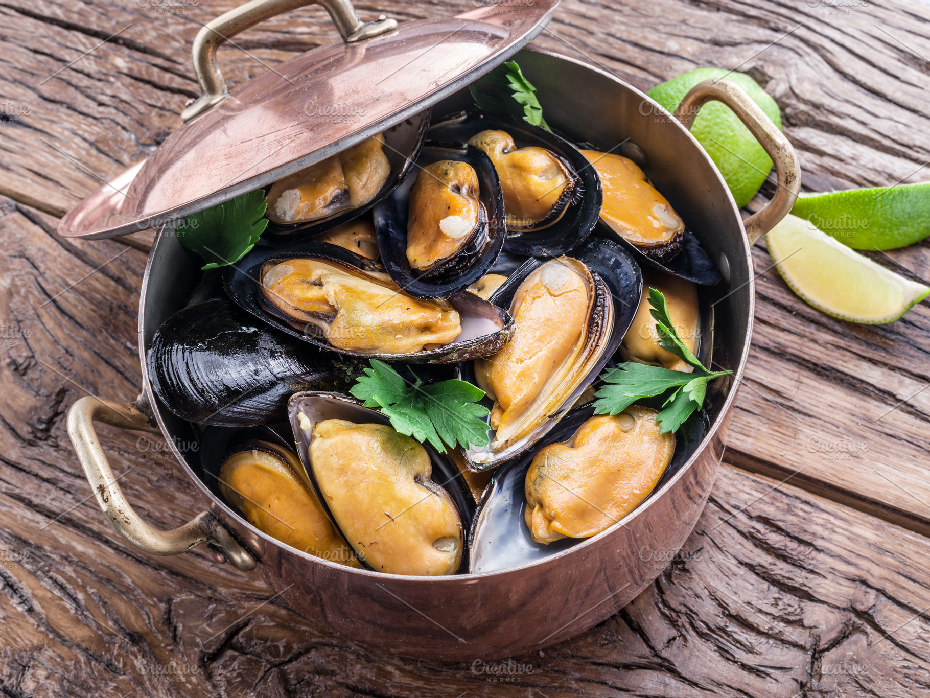 Mussels in copper pan on the wooden table., a Food & Drink Photo by Volff
