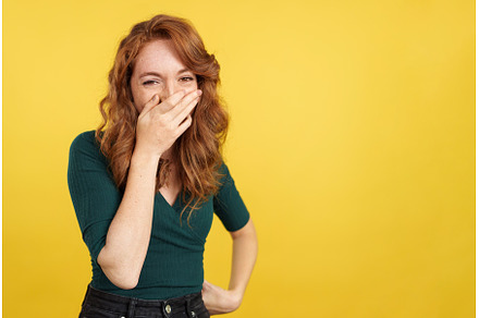 Shy redheaded woman covering the, a Person Photo by Iván Moreno STOCK PHOTO