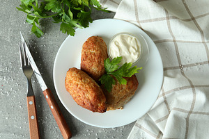 Concept of tasty food with cutlets on gray textured table, a Food & Drink Photo by AtlasStudio PRO