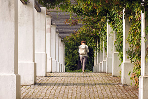 Woman walking away in outdoor alley, a Person Photo by BOOCYS