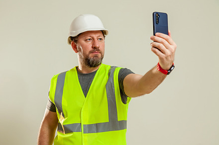 worker in a vest and white helmet, a Person Photo by Photostock