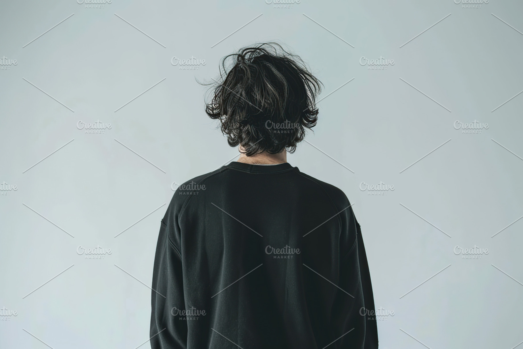 Young man in black sweatshirt on grey background, back view, a Beauty & Fashion Photo by AlyaAnd