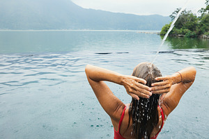 Young woman relax in infinity pool, a Person Photo by Tropical Studio