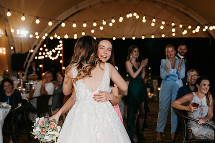 bride in a white dress throws a wedding bouquet