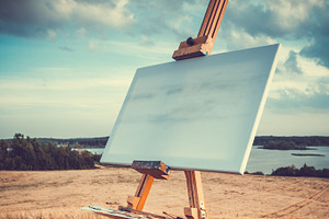 Blank canvas rests on easel outdoors